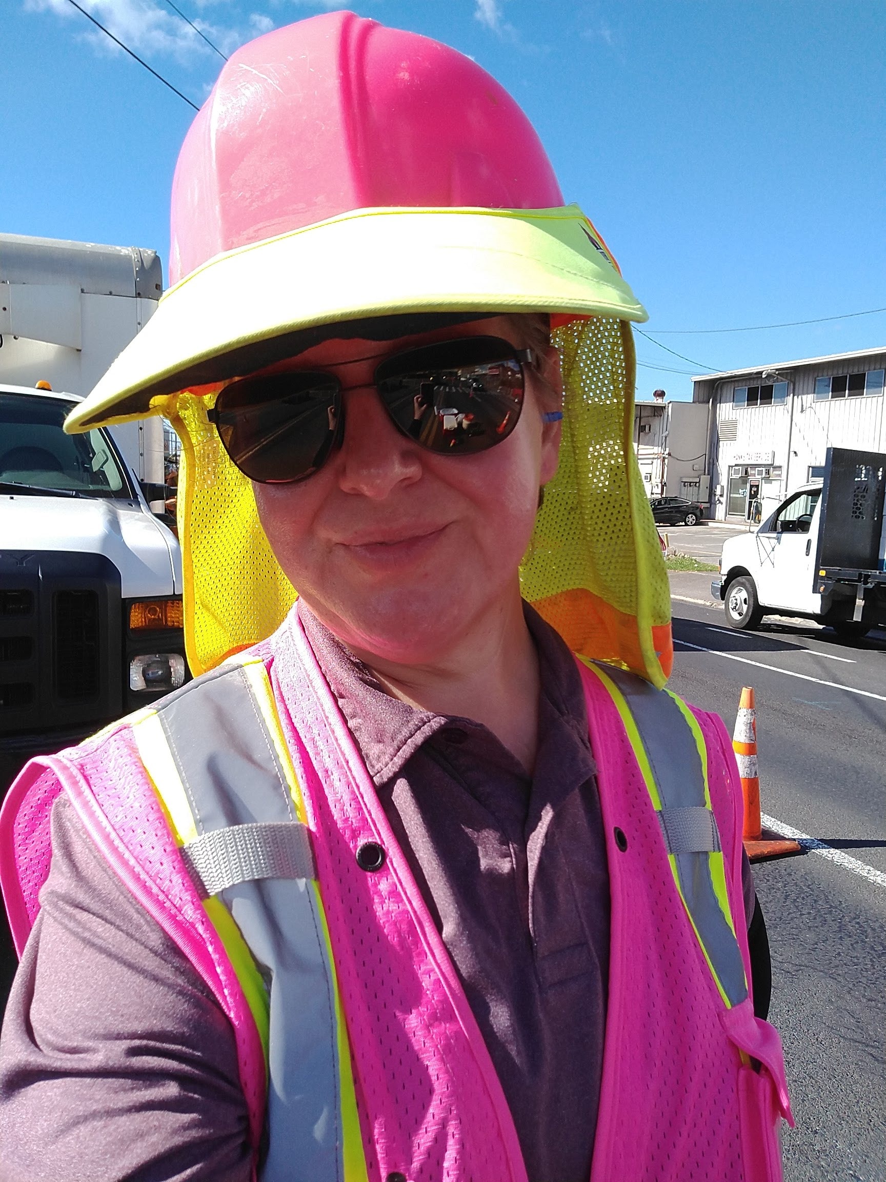 Kimberly Kim on a construction site wearing a pink hard hat and hi-vis vest