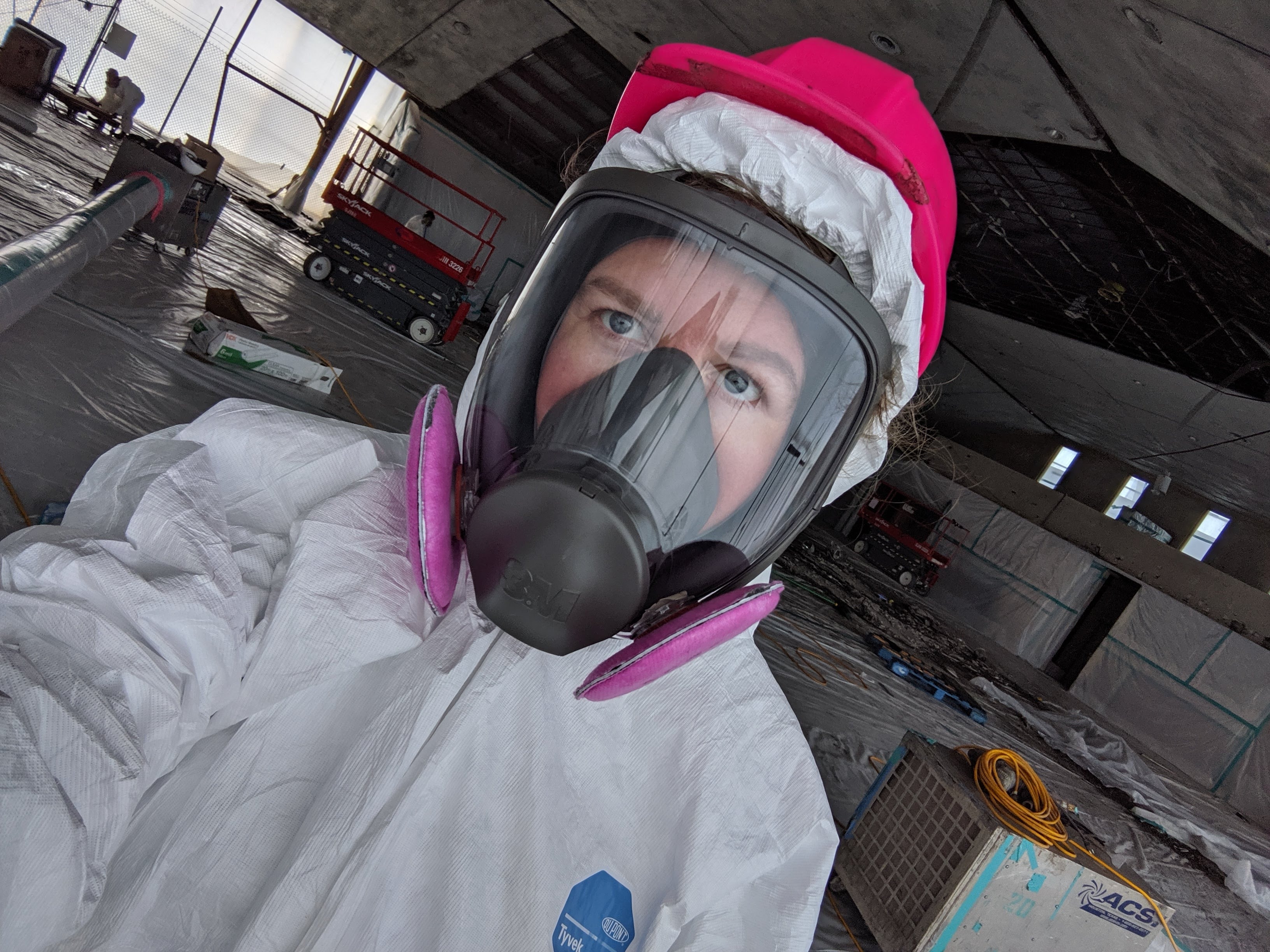 Kimberly Kim in full-face respirator and Tyvek suit during hazmat remediation
